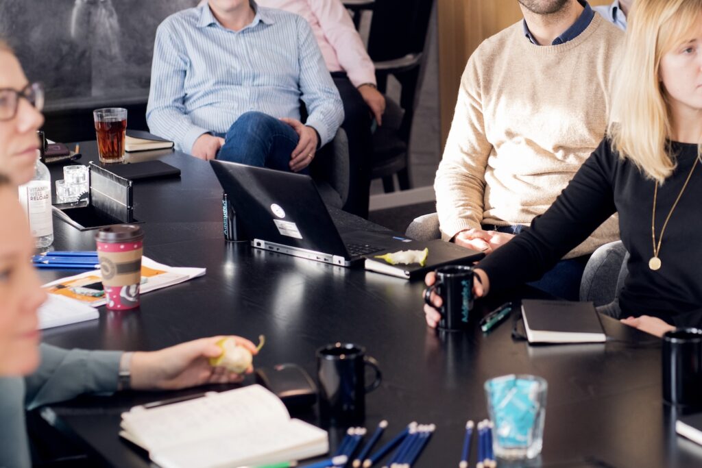 En grupp människor som sitter runt ett bord och arbetar